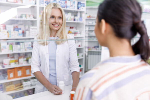 pharmacist and customer looking at each other in drugstore